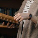 Image of a person holding a book in a library