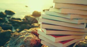Image of stack of books on a rocky beach