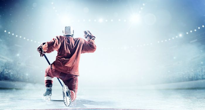 hockey player in red uniform kneeling on ice
