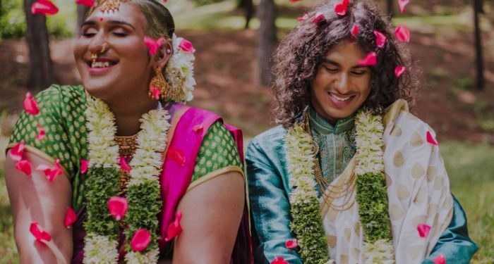 nonbinary Southeast Asian couple in traditional dress